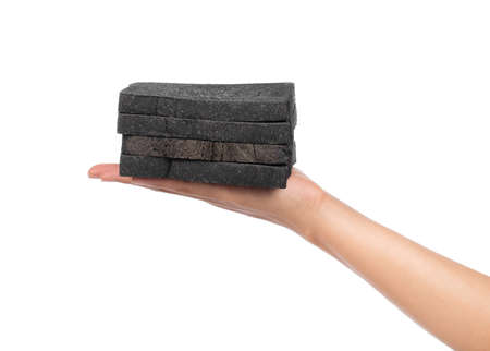 hand holding charcoal bread on plate isolated on white backgroundの写真素材