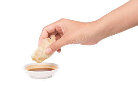 hand holding wonton with sour sauce isolated on white background.の写真素材