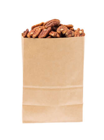 pecan nuts in paper bag isolated on white backgroundの写真素材