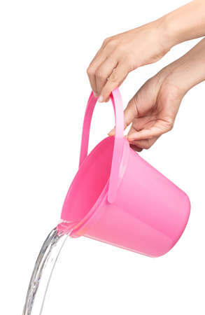 hand pouring water from plastic bucket isolated on white backgroundの写真素材