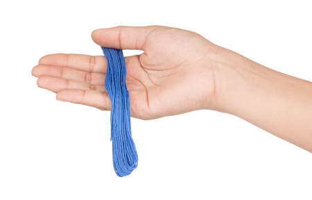 hand holding Close up blue yarn thread isolated on white backgroundの写真素材