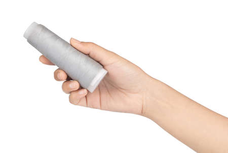 hand holding grey spool of thread isolated on white background