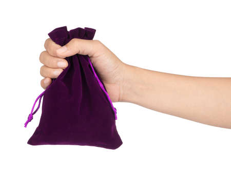 hand holding purple velvet bag isolated on white background