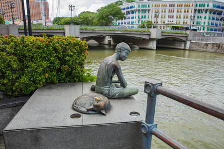 SINGAPORE - FEBRUARY 19, 2017: sculpture of Young man with dog location from the Singapore Riverのeditorial素材