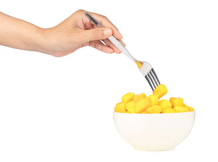 hand holding Sweet mango by a fork isolated on white background