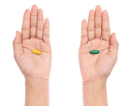 selection of pills capsules in hands isolated on white backgroundの写真素材