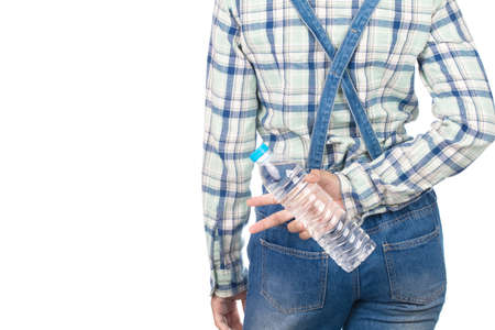 young woman in plaid shirt and bib jeans hand holding bottle water in the back pocket of the jeans...
