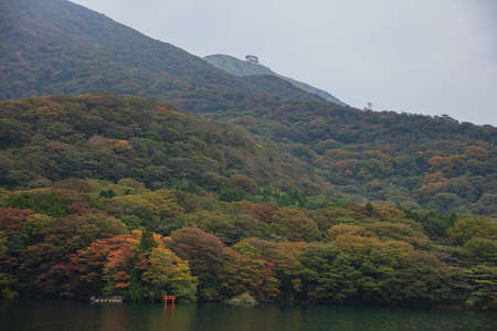 Lake Ashi with mountains  background with red torii gate submerged in the waters