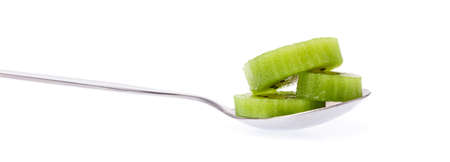 slice kiwi fruit on spoon isolated on white backgroundの写真素材