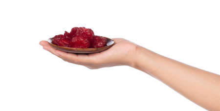 hand holding red date on dish isolated white background