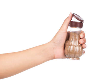 hand holding bottle of oregano isolated on white background