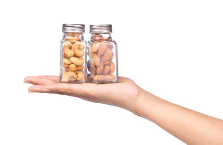 hand holding bottle of Cashew nuts with Almonds isolated on white backgroundの写真素材