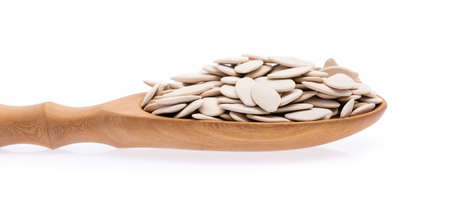 Wood ladle of Pumpkin seeds isolated on white backgroundの写真素材