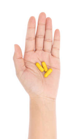 pills capsules in hand isolated on white backgroundの写真素材