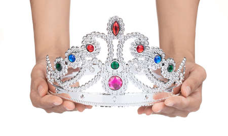 Hand holding Silver crown with jewels isolated on white backgroundの写真素材