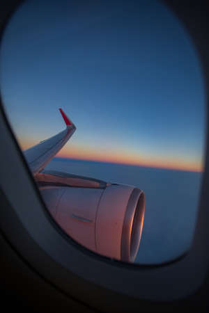 wing of an airplane in a porthole on a blue sky