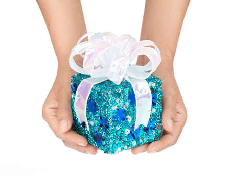 Hand holding blue gift box with ribbon isolated on white background