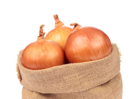 fresh onion in burlap sack bag isolated on white backgroundの写真素材