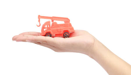 hand holding a toy tractor isolated on a white background.の写真素材