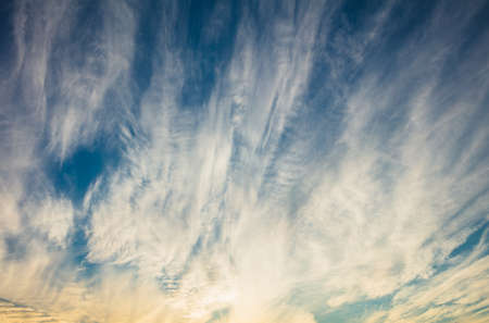 Sky blue and orange light of the sun through the clouds and the skyの写真素材