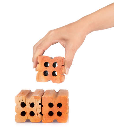 hand holding red brick isolated on white backgroundの写真素材