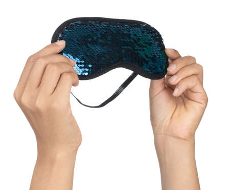 Hand holding Blue sleeping eye mask with sequins that look like fish scales isolated on white...