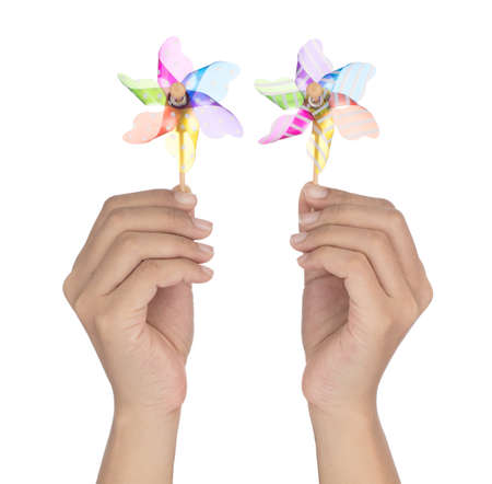 Hand holding two colorful pinwheel isolated on white background