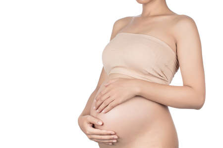 Young pregnant woman embracing her naked abdomen with hands. isolated on white background