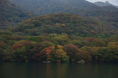 Lake Ashi with mountains  background with red torii gate submerged in the waters