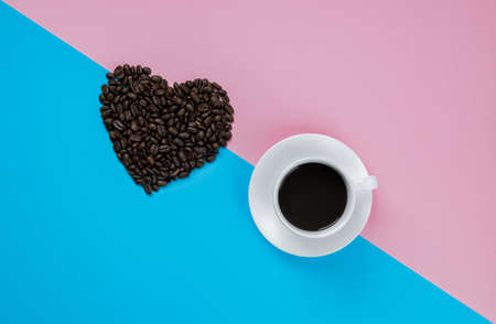 Black coffee in white cup on pink and blue backgroundの写真素材
