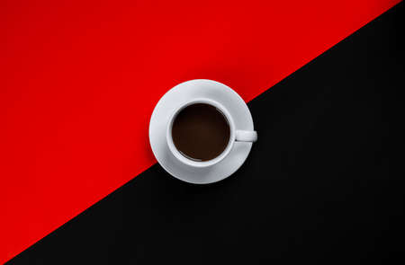 Black coffee in white cup on red and black background