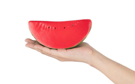 Hand holding Watermelon for decoration artificial fruit ornaments artificial foam fake imitation isolated on white backgroundの写真素材