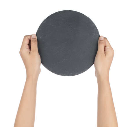 Hand holding Black round stone plate isolated on white backgroundの写真素材