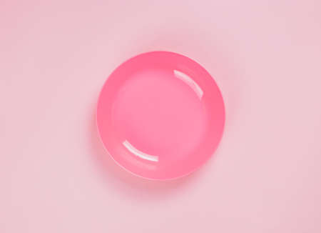 Pink plastic plate on pink backgroundの写真素材