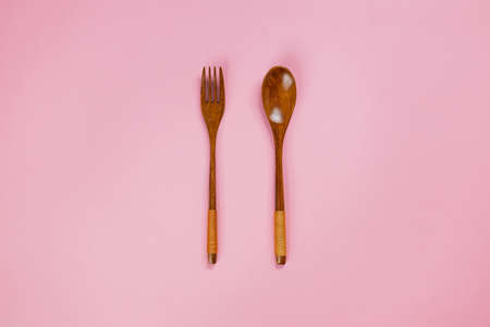 Close Up of wood spoon and fork on pink backgroundの写真素材
