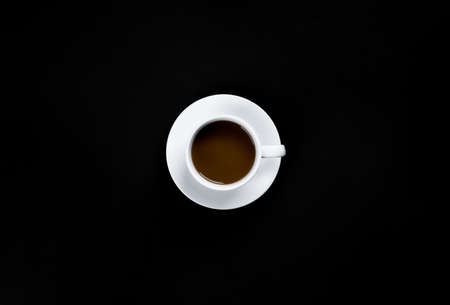 Black coffee in white cup on a black background