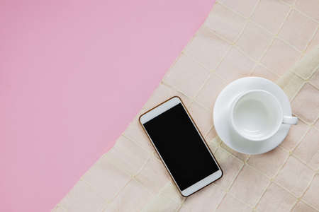 Smartphone and cup coffee on a pink background の写真素材