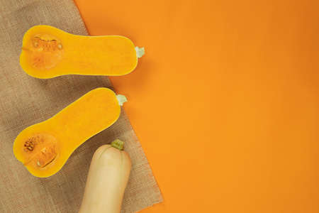 Butternut squash with tablecloth on orange background