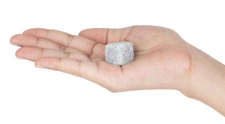 Hand holding Rock soapstone ice cube isolated on white background