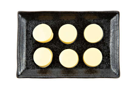 Fresh egg tofu sliced on stone plate isolated on white background.