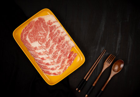 Beef slice in tray on black background