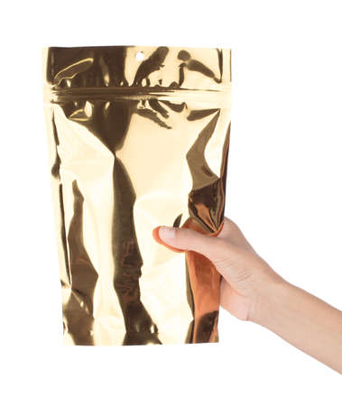 Hand holding Golden Blank plastic Potato snack Bag Packaging With zip-lock isolated on white...