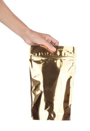 Hand holding Golden Blank plastic Potato snack Bag Packaging With zip-lock isolated on white...
