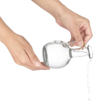 Pouring out water from a bottle isolated on white background.