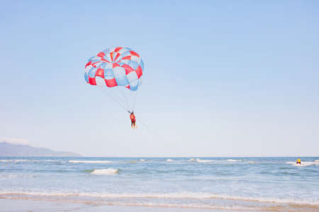 Parachuting over a sea, towing by a boatの写真素材