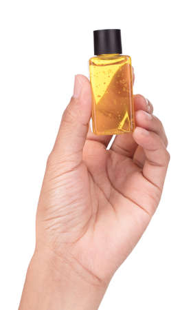 Hand holding Bottle with face serum isolated on white âbackgroundの写真素材