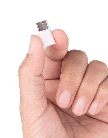 Hand holding Micro USB to USB-C adapter isolated on white background