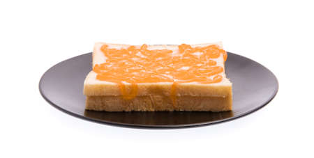 dish of bread with orange jam isolated on white background