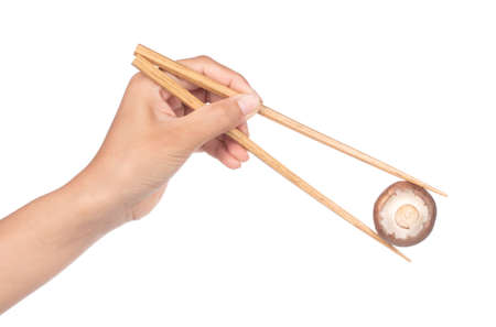 hand holding chopsticks with Champignon Mushroom isolated on white backgroundの写真素材