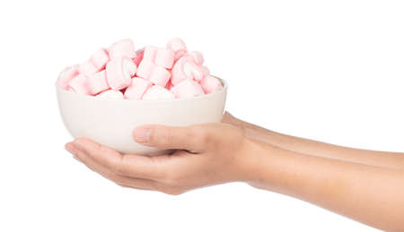hand holding heart shape of marshmallow on bowl isolated on white background.の写真素材